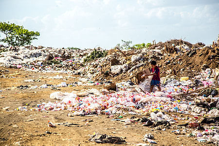 child scavenging on garbage pile at daytime thumbnail