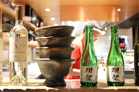 two green bottles near bowls thumbnail