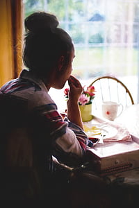 man in white and pink top sitting beside table thumbnail