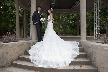 man in black suit standing beside woman wearing white wedding dress thumbnail