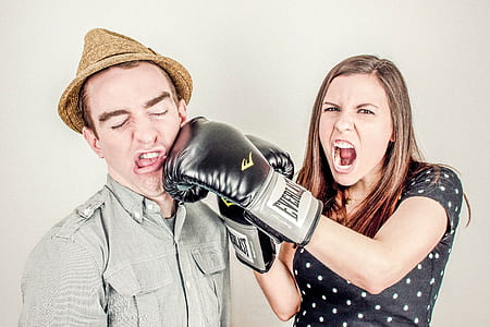 woman wearing black Everlast boxing gloves beside man wearing brown fedora hat thumbnail
