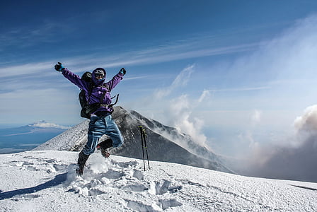 man wearing purple jacket near mountain under blue sky during daytime thumbnail