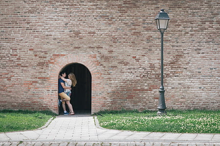 man and woman standing beside door near light post thumbnail