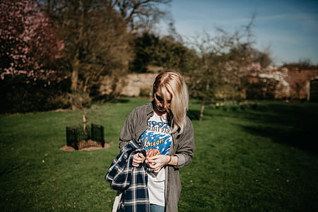 selective focus photography of woman standing on green grass field thumbnail