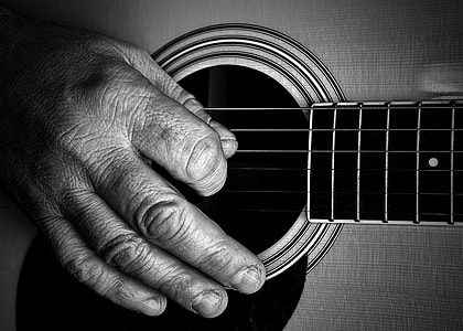 grayscale photo of person playing guitar thumbnail