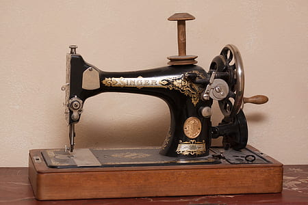 black and gray Singer sewing machine beside wall thumbnail