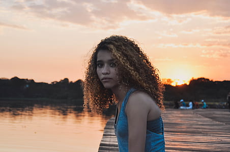 woman in blue tank top on wooden surface near water thumbnail