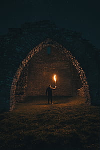 man carrying torch inside arc-shaped brick shed thumbnail
