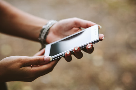 Young woman holding the white mobile phone thumbnail