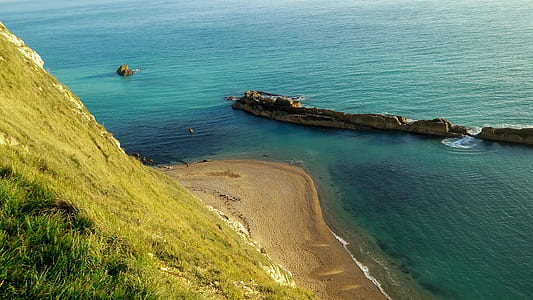 landscape photography of ocean near green grass thumbnail