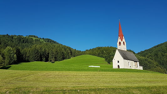 white and gray cathedral surrounded by green grass field thumbnail