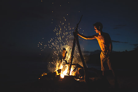 boy making bonfire under night time sky thumbnail