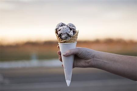person holding ice cream cone with cookies and cream ice cream thumbnail