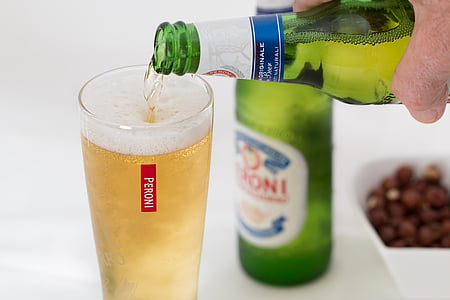 person pouring liquor on clear glass thumbnail