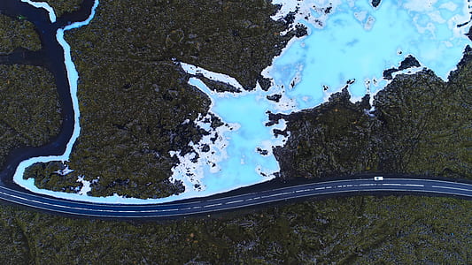 aerial photography of road near body of water and forest thumbnail