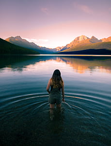 woman walking on body of water during daytime thumbnail