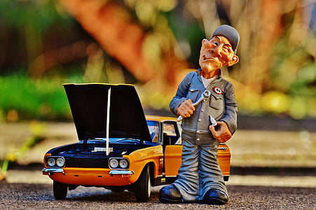 mechanic in grey shirt standing on orange classic car miniature thumbnail
