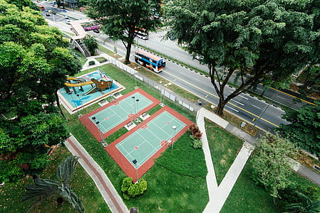 tennis field near double decker bus traveling on road at daytime thumbnail