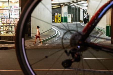woman walking on road beside concrete building during nighttime thumbnail