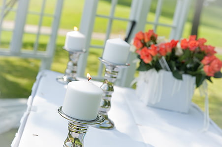 three lighted white pillar candles on glass candle holders thumbnail