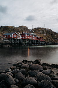 brown wooden houses over body of water thumbnail