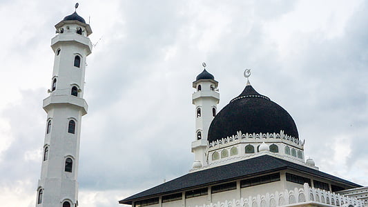 low angle photo of white and black cathedral under white cloudy skies thumbnail