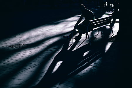low-light photo of person sitting on bench thumbnail