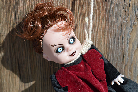 black and red dressed doll with hanging rope on neck beside brown wooden plank thumbnail