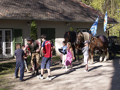 children surrounding cowboy near horses and house thumbnail