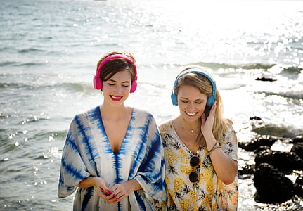 two woman standing near body of water during daytime thumbnail