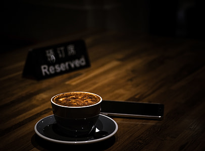 black ceramic cup with brown liquid on top of plate thumbnail