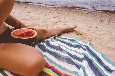 person sitting on seashoe eating melon thumbnail