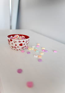 round white and red heart-printed ceramic bowl on table thumbnail