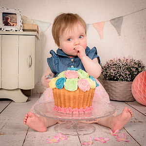 girl sitting beside the cake on table thumbnail