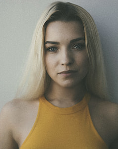 woman in yellow halterneck top standing near wall thumbnail