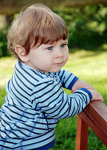 toddler holding on brown wooden rack thumbnail