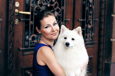 Woman Carrying Adult White Indian Spitz thumbnail