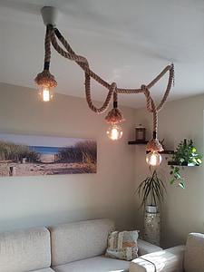 brown 3-light pendant lamp near white sofa turned-on thumbnail