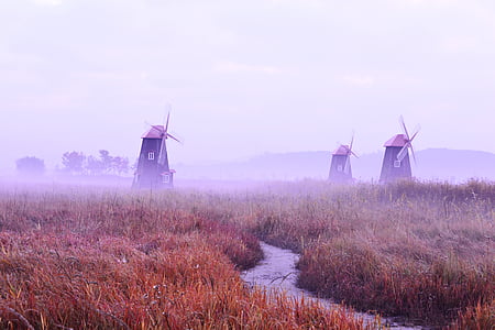 three wind mills on brown and green grass field thumbnail