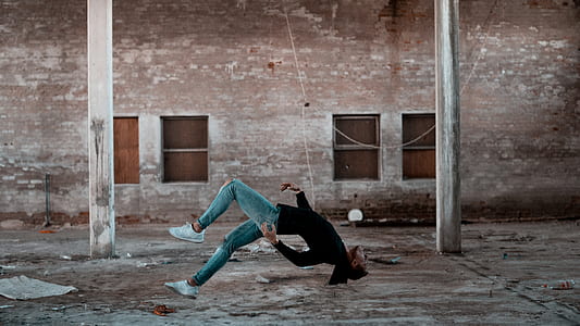 man defying gravity inside brown concrete building thumbnail
