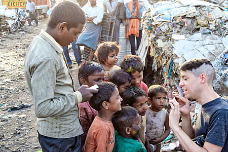 children walking to man with blue crew-neck shirt during daytime close-up photo thumbnail