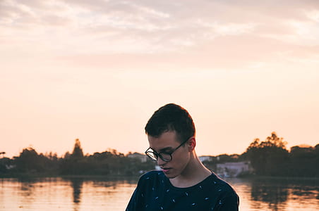 man standing near body of water under white cloudy skies at daytime thumbnail