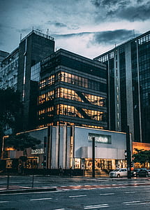 Black High Rise Building Under Grey and White Sky during Night Time thumbnail