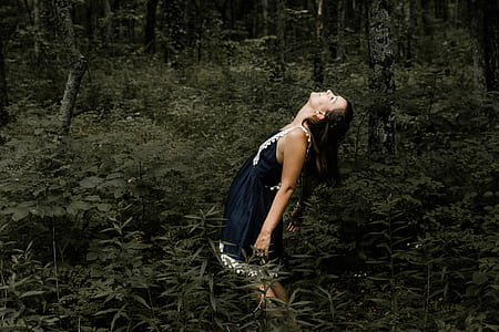 woman standing under green trees during daytime photo thumbnail