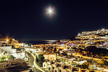 houses and buildings near sea at night time thumbnail