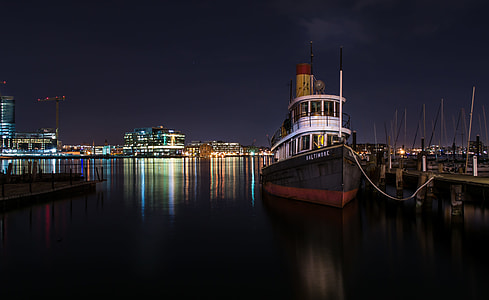 black, red, and white ship beside dock thumbnail