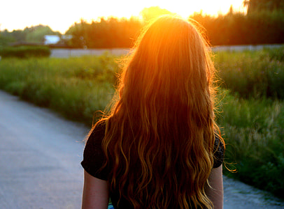 woman wearing black shirt standing on road during golden hour thumbnail
