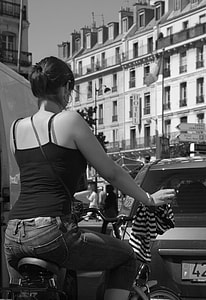 grayscale photography of a woman in black tank top riding black hybrid mountain bike thumbnail