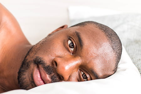 man lying on white pillow in side position thumbnail