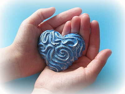 person holding heart-shaped blue stone thumbnail